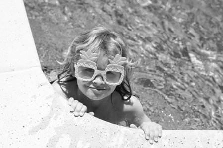 Happy child playing in swimming pool. Summer kids vacation. Little kid boy relaxing in a pool having fun during summer vacation.の写真素材