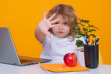 Stop bullying. Sad and angry pupil. Nerd pupil boy from elementary school with book isolated on yellow studio background. Smart genius intelligence kid ready to learn. Back to school.の写真素材
