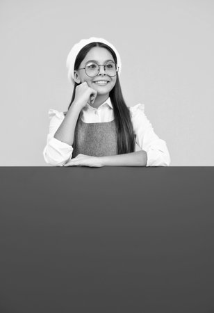 Teenage girl holds a blank for notification informing. Advertisement and sale. Markets and shops sales concept, blank board for copy space. Happy face, positive and smiling emotions of teenager girl.の写真素材