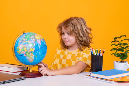 School child student learning in class looking at globe during geography lesson at school. Elementary school child. Portrait of funny pupil learning.の写真素材