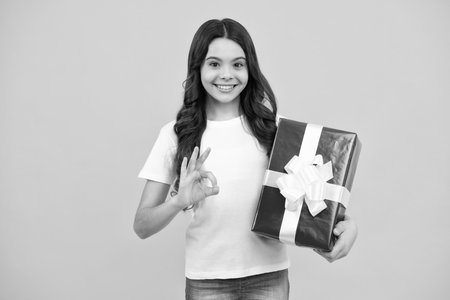 Cute child girl congratulate with valentines day, giving romantic gift box. Present, greeting and gifting birthday concept. Happy teenager, positive and smiling emotions of teen girl.の写真素材