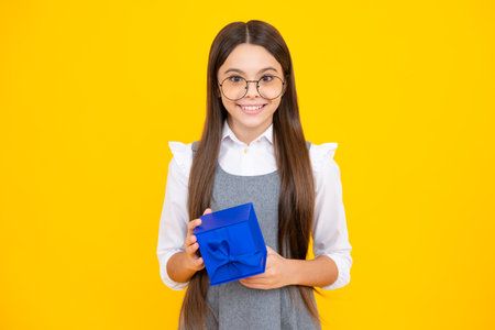 Emotional teenager child hold gift on birthday. Funny kid girl holding gift boxes celebrating happy New Year or Christmas.の写真素材