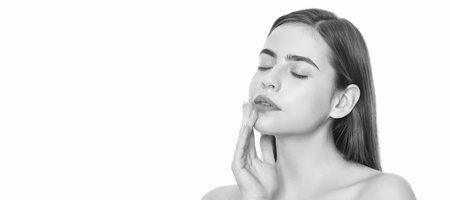 Beauty woman skin. young woman touch soft face skin with closed eyes isolated on white background, skincare. Woman beauty face, close up portrait, isolated banner with copy space.の写真素材