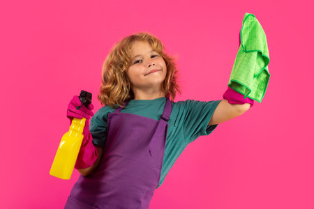 Little kid cleaning at home. Child doing housework having fun. Studio isoalted portrait of child housekeeper with wet flat mop on pink background.の写真素材