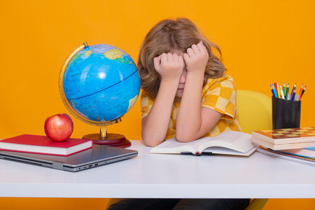 Sad, tired and bored pupil. School and education concept. Portrait of cute child school boy, isolated on yellow background. Back to school.の写真素材