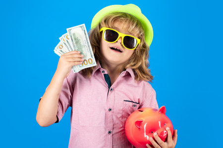 Saving money for travel. Dollars money and piggybank concept. Kid saving money in a piggy bank, learning about saving, Kid save money in piggybank.の写真素材