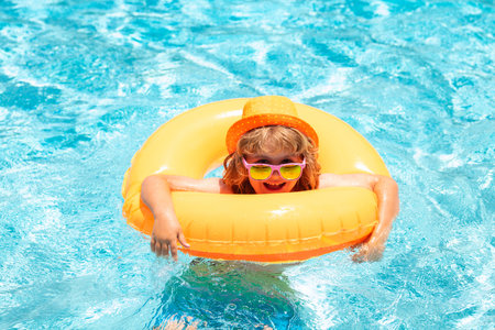 Boy swimming and playing in a pool. Child playing in swim pool. Summer vacation concept. Summer kids portrait.の写真素材