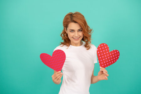 happy young lady with red heart on blue backgroundの写真素材