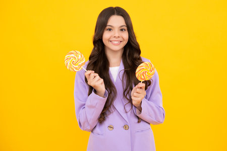 Teenage girl with candy lollipop, happy child 12, 13, 14 years old eating big sugar lollipop, sweets candy. Happy teenager, positive and smiling emotions of teen girl.の写真素材