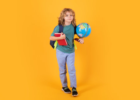 School boy with backpack. Little student on yellow isolated background. Learning, education and knowledge.の写真素材