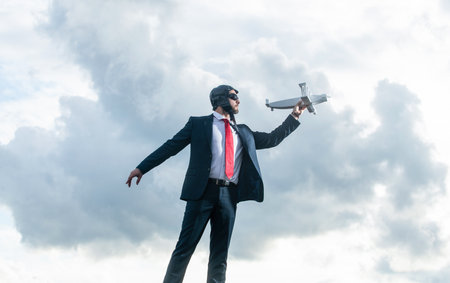 businessman in suit and pilot hat launch plane toy on sky background. start upの写真素材