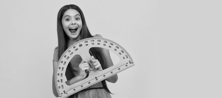 surprised kid study math in school hold protractor ruler, mathematics. Horizontal isolated poster of school girl student. Banner header portrait of schoolgirl copy space.の写真素材
