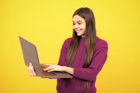 Teenager school girl hold notebook laptop. School children on isolated studio background.の写真素材