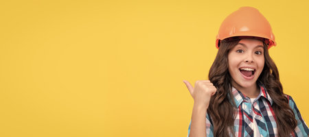 Builder teenager girl in helmet. happy teen girl with curly hair in construction helmet hold alarm clock, success. Child builder in helmet horizontal poster design. Banner header, copy space.の写真素材