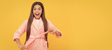 amazed teen girl in home terry bathrobe, homewear. Child face, horizontal poster, teenager girl isolated portrait, banner with copy space.の写真素材