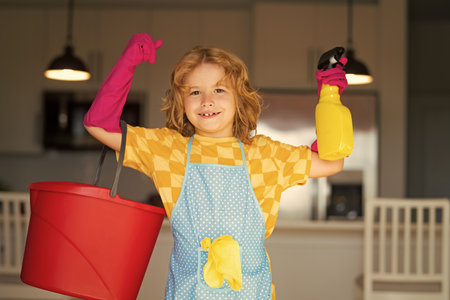 Child use duster and gloves for cleaning. Funny child mopping house. Cleaning accessory, cleaning supplies. Housekeeping and home cleaning.の写真素材