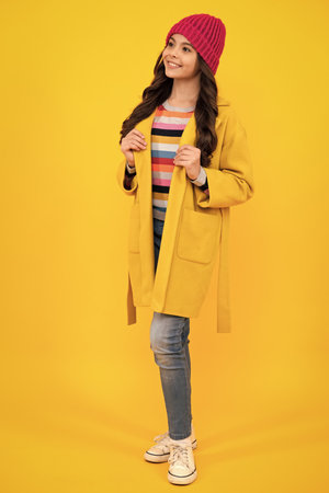 Full length of her she attractive pretty lovely cute cheerful cheery teenager child girl isolated over vivid yellow background. Happy teenager, positive and smiling emotions of teen girl.の写真素材