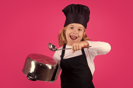 Fynny kid chef cook with cooking pot and ladle. Kid chef cook, studio portrait. Children cooking. Kid boy with apron and chef hat.の写真素材