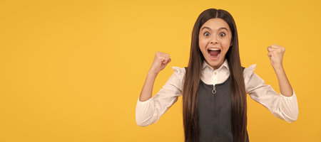 Happy teenage girl winner give winning gesture celebrating victory yellow background, won. Child face, horizontal poster, teenager girl isolated portrait, banner with copy space.の写真素材