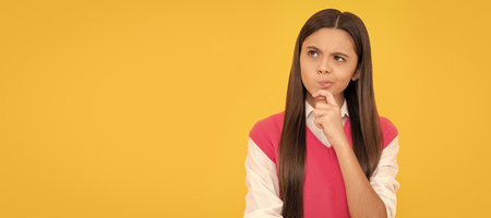 thinking teen school girl with long hair on yellow background, decision. Child face, horizontal poster, teenager girl isolated portrait, banner with copy space.の写真素材