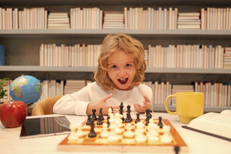 Little child play chess in classroom. Kid playing board game. Thinking child brainstorming and idea in chess game. Chess school and education concept.の写真素材