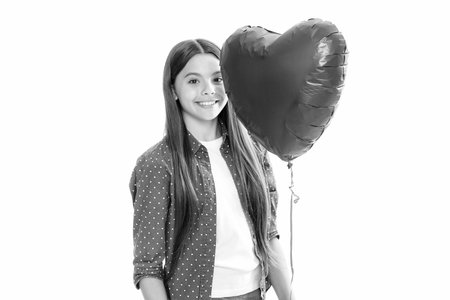 Young teenager child girl with heart shape balloon. Happy Valentines Day. Love and pleasant feelings concept. Portrait of happy smiling teenage child girl.の写真素材