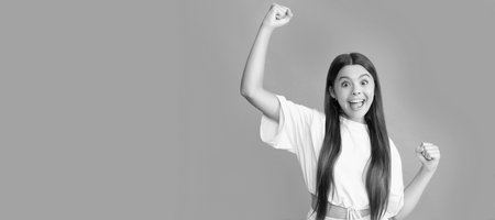 happy successful kid with long hair on blue background, success. Child face, horizontal poster, teenager girl portrait, banner with copy space.の写真素材