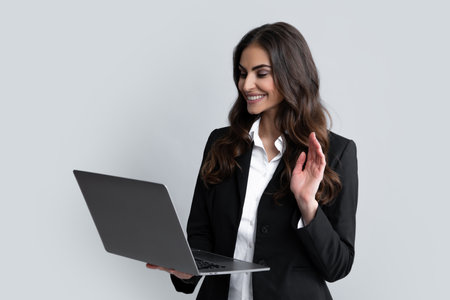 Pretty assistant holding notebook search information internet. Young business woman with laptop computer isolated studio portrait on gray background. Freelancer at work.の写真素材