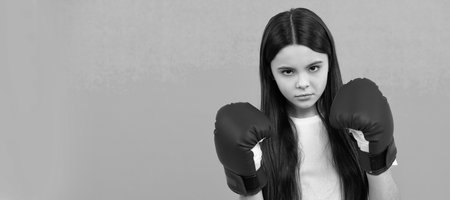 always ready. power and authority. girl in sportswear boxing gloves. sport challenge. punching. Horizontal poster of isolated child face, banner header, copy space.の写真素材