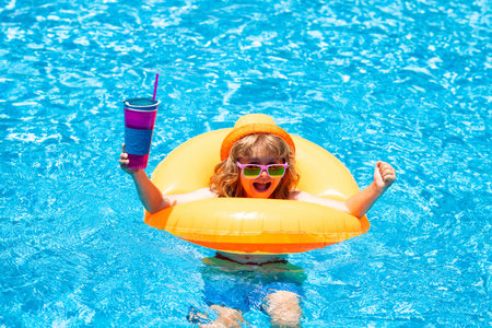 Child boy splashing in swimming pool. Swim water sport activity on summer vacation with children.の写真素材