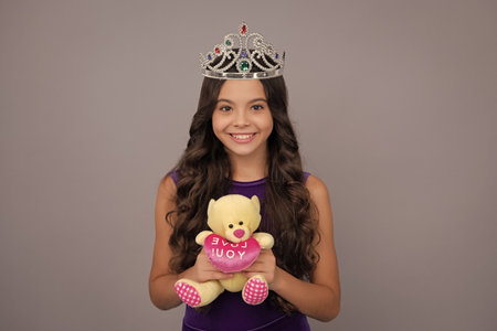 Girls party, funny kid in crown. Child queen wear diadem tiara. Cute little princess portrait. Happy girl face, positive and smiling emotions.の写真素材