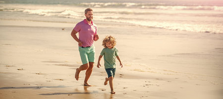 Banner of father and son run on summer sea beach. dad and child having fun outdoors. childhood and parenting. father and sonの写真素材