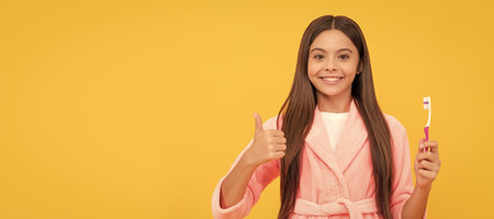 oral care. self hygiene. daily habit. happy teen girl hold toothbrush. childhood happiness. Banner of child girl with teeth brush, studio portrait, header with copy space.の写真素材