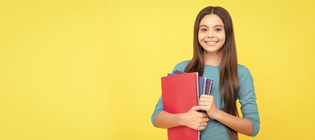 cheerful child girl hold notepad for homework, homework. Banner of schoolgirl student. School child pupil portrait with copy space.の写真素材