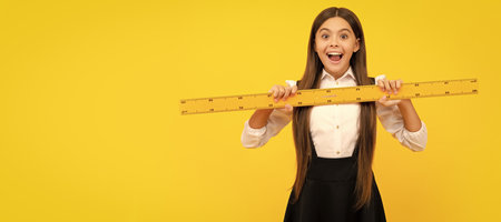 amazed kid in school uniform hold mathematics ruler for measuring, education. Banner of school girl student. Schoolgirl pupil portrait with copy space.の写真素材