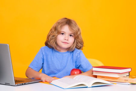 School kid reading book. School kids isolated on yellow background. Child from elementary school. Pupil go study. Clever schoolboy learning. Kids study, knowledge and education concept.の写真素材
