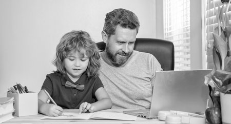 homeschooling and elearning. back to school. father and son use computer at home.の写真素材