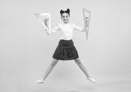 Teenager school girl study math or geometry lesson, measure the size. Mathematics ruler for measuring. Happy positive and smiling schoolgirl.の写真素材