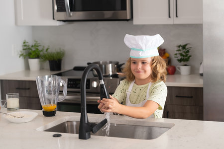 Kid chef cook is learning how to make a cake in the home kitchen. Child making tasty delicious. Eggs, milk and flour ingredients for baking cookies or pancakes.の写真素材