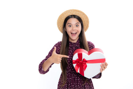 Portrait of emotional amazed excited teen girl. Surprised teenage child holding gift box on white isolated background. Gift for kids birthday. Christmas or New Year present box.の写真素材