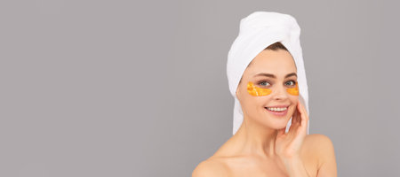 Eye patches, patch under eyes. Smile with reflection of glow. moisturizing skin. cosmetology. young woman. Beautiful woman isolated face portrait, banner with mock up copy space.の写真素材