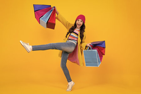 Teenager hold shopping bag enjoying sale. Child girl is ready to go shopping. Winter shopping sale. Happy teenager, positive and smiling emotions of teen girl.の写真素材