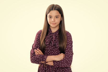 Cute little teenager girl crossing arms over white background.の写真素材