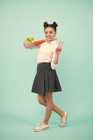 Teenagers youth casual culture. Teen girl with skateboard over isolated studio background. Teenager in fashion stylish clothes.の写真素材