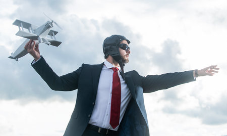 businessman in suit and pilot hat launch plane toy. motivationの写真素材