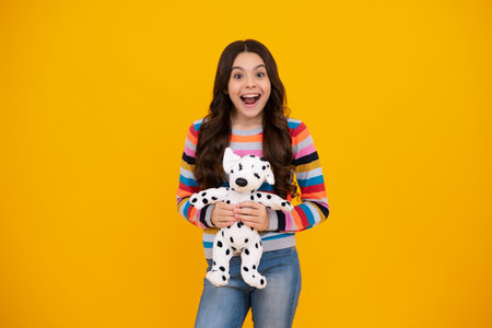 Amazed teenager. Childhood, toys and kids. Cute teen girl cuddling fluffy toy. Excited teen girl.の写真素材