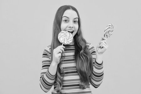 Teenager girl with caramel candies on sticks, sweet sugar addiction. Child with lollipops.の写真素材