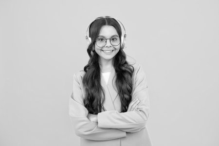 Stylish teenage girl listening to music with headphones. Kids lifestyle concept. Wireless earphones.の写真素材