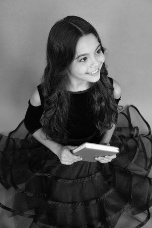 Teenager schoolgirl hold book and copybook ready to learn. School children on isolated grey background. Happy face, positive and smiling emotions of teenager schoolgirl.の写真素材