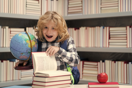 Excited pupil. Back to school. Funny little child from elementary school with book. Education. Kid study and learning.の写真素材